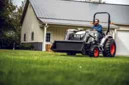 Bobcat ct2025 compact tractor with front-end loader in front of a barn